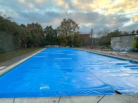 Outdoor pool covered using Two covers on a piggyback reel system